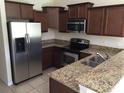 Modern kitchen with stainless steel appliances and granite countertops at 10975 Savannah Landing Cir, Orlando, FL 32832