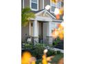 Front entryway with stone pillars, a beige door, and lush landscaping at 11574 Buoy Point Pl, Orlando, FL 32832