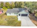 Single story house with gray roof, and a paved driveway at 1267 Varnado Rd, Groveland, FL 34736