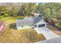 Single story house with gray roof, and a paved driveway at 1267 Varnado Rd, Groveland, FL 34736