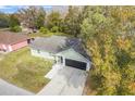 Single story house with gray roof, and a paved driveway at 1267 Varnado Rd, Groveland, FL 34736