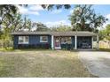 Ranch-style home with red door and carport at 128 Tildenville School Rd, Winter Garden, FL 34787