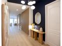 Bright and airy entryway with hardwood floors, a statement piece of art, and a modern console table at 13586 Abberwick Dr, Orlando, FL 32832