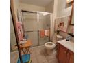 Cozy bathroom with a glass-enclosed shower, neutral tile, and a wood-style vanity at 1420 Thousand Roses S Dr, Lake Wales, FL 33853