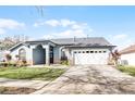 Front view of a charming one-story home with a white garage door at 16143 Palmetto Hill St, Clermont, FL 34714