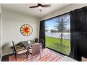 Outdoor lanai with comfortable seating, ceiling fan, and a view of the lake with fountain at 17597 Summersweet Way, Clermont, FL 34714