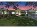 House exterior at sunset, red door, landscaping, and driveway at 176 Nandina Ter, Winter Springs, FL 32708