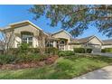 Green house exterior with red door, landscaping, and driveway at 176 Nandina Ter, Winter Springs, FL 32708