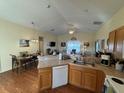 Open concept kitchen with island, wood cabinets, and a view into the dining area at 241 Shady Ln, Deland, FL 32724