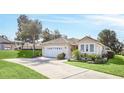 Single-story house with a two-car garage and lush landscaping at 303 Foxhill Ct, Debary, FL 32713