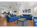 Living room with hardwood floors, blue sofas, and a view of the kitchen at 3163 Britannia Blvd # D, Kissimmee, FL 34747