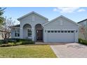 Gray house with a two-car garage and a brick paved driveway at 3999 Night Heron Dr, Sanford, FL 32773