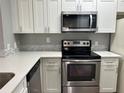 Stainless steel appliances and white shaker cabinets in this updated kitchen at 5538 Pga Nw Blvd # 5025, Orlando, FL 32839