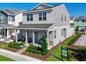 Two-story house with gray siding, a front porch, and landscaping at 5586 Stockade Blvd, St Cloud, FL 34771