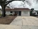 The house exterior shows gray paint, a large driveway, and a tree in front at 610 Thomas Ave, Winter Haven, FL 33880