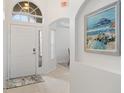 Bright and airy entryway with tiled floors and beach art at 627 Copeland Dr, Haines City, FL 33844