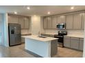 Modern kitchen with gray cabinets, stainless steel appliances, and an island at 768 Staffora St, Haines City, FL 33844