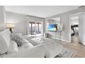 Bright living room featuring a white sectional sofa and hardwood floors at 7729 Country Pl, Winter Park, FL 32792