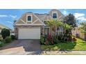 Attractive two-story house with stone and beige siding, a three-car garage, and lush landscaping at 820 Spring Oak Cir, Orlando, FL 32828