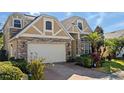 Stunning two-story house, stone and beige accents, three-car garage, manicured landscaping at 820 Spring Oak Cir, Orlando, FL 32828