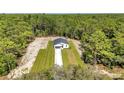 Breathtaking aerial view of a modern home nestled in a serene, wooded landscape at 9095 Sw 125Th Ter, Dunnellon, FL 34432