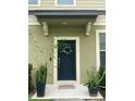 Modern front door with decorative wreath and potted plants at 1100 Pavia Dr, Apopka, FL 32703