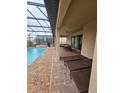 Screened-in pool area with lounge chairs and patio furniture at 1662 Lima Ave, Kissimmee, FL 34747