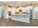 Modern kitchen with white cabinets, granite counters, and stainless steel appliances at 530 Windy Pine Way, Oviedo, FL 32765