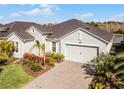 One-story house with light green exterior, landscaping and paver driveway at 636 Mosaic Blvd, Daytona Beach, FL 32124