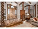 Grand foyer showcasing a wooden front door, decorative columns, and tile flooring at 661 Cricklewood Ter, Lake Mary, FL 32746