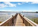 Scenic wooden dock extending over a tranquil lake at 7387 Duxbury Ln, Winter Garden, FL 34787
