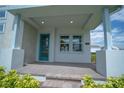 Inviting front porch with brick flooring and a stylish blue front door at 9856 Sharpless Aly, Orlando, FL 32827