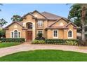 Two-story house with tile roof, landscaping, and brick driveway at 10018 Lone Tree Ln, Orlando, FL 32836