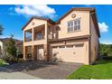 Two-story house with tan exterior, two-car garage, and balcony at 10233 Henbury St, Orlando, FL 32832