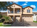 Two-story house with tan exterior, two-car garage, and balcony at 10233 Henbury St, Orlando, FL 32832