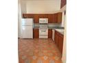 Galley kitchen with wood cabinets and tile floors at 10418 Reagans Run Dr, Clermont, FL 34711