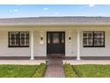 Close-up of a home's front entrance featuring a decorative glass door, black window trim and a brick walkway at 3010 Bay Tree Dr, Orlando, FL 32806