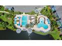 Aerial view of the community pool featuring dual pool areas, lounge seating, and surrounding greenery at 3013 Bonfire Beach Dr # 101, Kissimmee, FL 34746