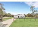 White house with a driveway and wooden fence, sits on a spacious lot at 39641 Royal Trails Rd, Eustis, FL 32736