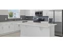 A kitchen featuring white cabinetry, stainless appliances and a center island at 520 Orient Ave, Debary, FL 32713