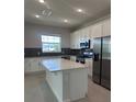 Bright kitchen with stainless steel appliances, white cabinetry, and a large island at 520 Orient Ave, Debary, FL 32713