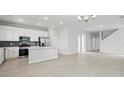 Open-concept living area featuring modern lighting, sleek tile flooring and flowing to the kitchen at 520 Orient Ave, Debary, FL 32713
