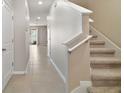Modern staircase with carpeted steps and tile flooring at 5427 Dragonfly Dr, Wildwood, FL 34785