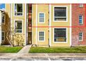 Detailed view of apartment building exterior showcasing yellow siding, balconies, and brick accents at 5600 Devonbriar Way # 204, Orlando, FL 32822