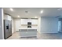 Modern kitchen with white cabinets, quartz countertops, and stainless steel appliances at 849 Rivers Crossing St, Clermont, FL 34714
