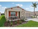 One story home with a two-car garage, red accents and landscaping at 9552 Starling Loop, Leesburg, FL 34788