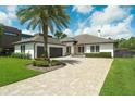 Beautiful single-story home features a brick driveway, manicured lawn, and a modern design at 10416 Pocket Ln, Orlando, FL 32836