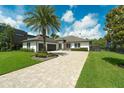 Gorgeous home boasts a sprawling front lawn, a paver driveway, and professional landscaping at 10416 Pocket Ln, Orlando, FL 32836