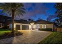 Exterior elevation of a beautiful home at dusk with a large driveway and stone accents at 10416 Pocket Ln, Orlando, FL 32836