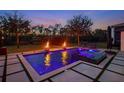 Backyard pool with an integrated spa, fire bowls, and lush landscaping at sunset at 10416 Pocket Ln, Orlando, FL 32836